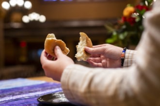 A woman breaks bread during communion