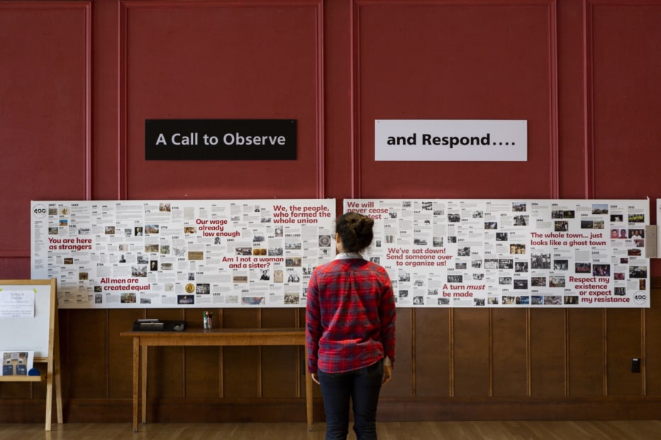 A young woman examines a mural showing a history of justice response