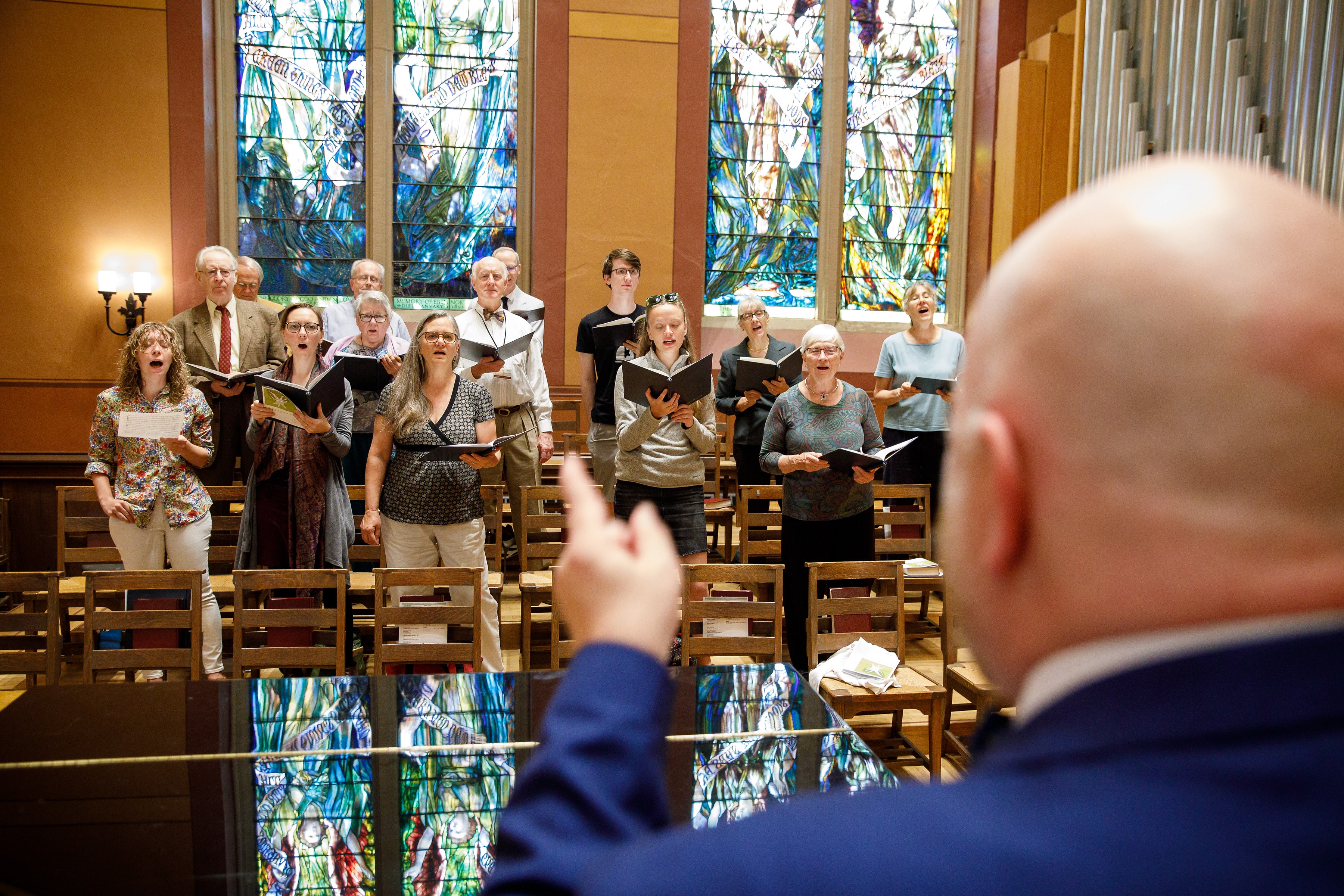 Peter directing the choir, People Staff a choir director and a church choir