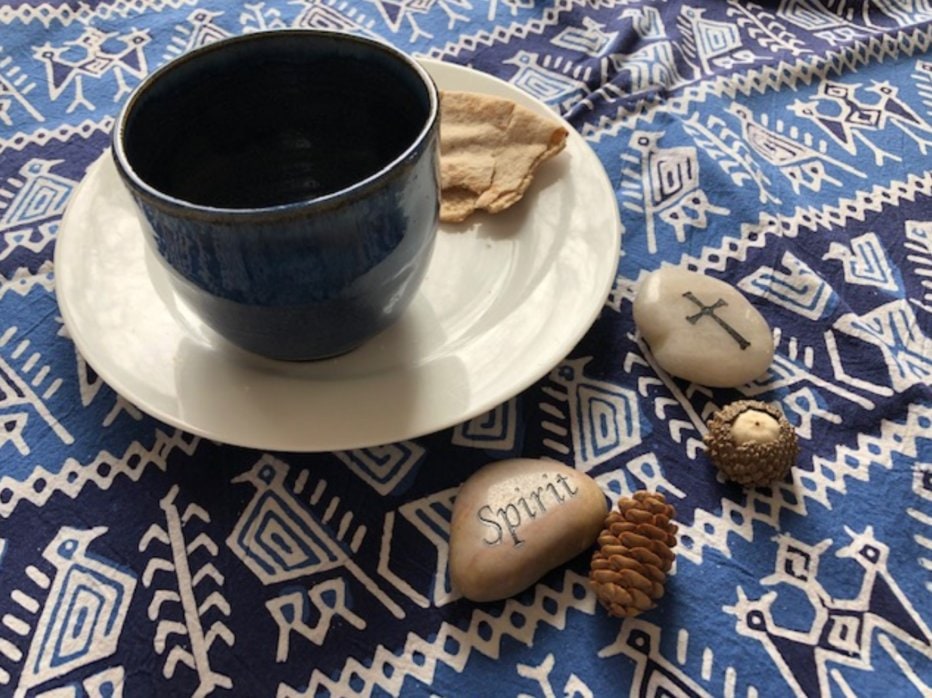 a cup and plate on a table cloth